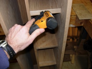 Glueing and pin nailing first shelf face