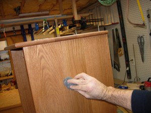Sanding the cabinet with steel wool