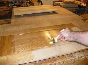 Applying a coat of finish to the doors