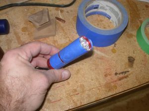 Add tape to flash light and press in place